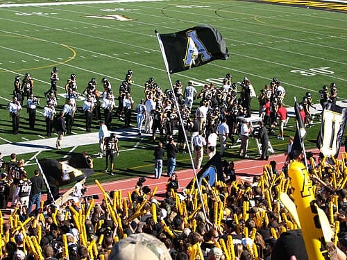 The Mountaineer football team gathers on the sideline