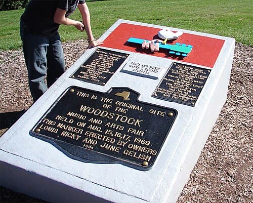 Peace and Music Woodstock monument with plaques by sculptor Wayne C. Saward and erected in 1984 on the festival site (note that John Sebastian's surname is misspelled as "Sabastian" and Bert Sommer's name is missing)[129]